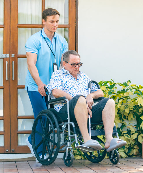 A caregiver helping a wheelchair-bound senior at home.